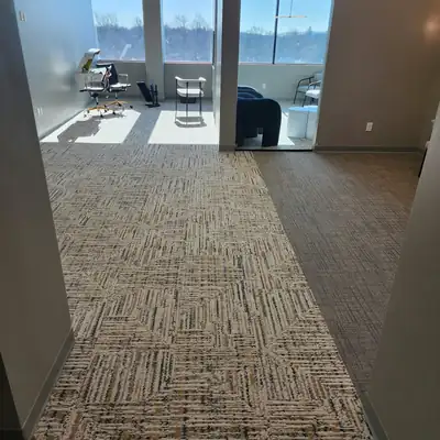 Carpet tile in an office corridor leading to windows