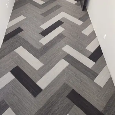 Black, gray and white geometric patterned carpet tile in an office corridor