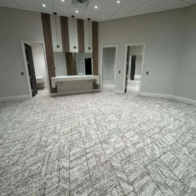 Gray and white patterned carpet tile in an office suite with wood-slat accent walls