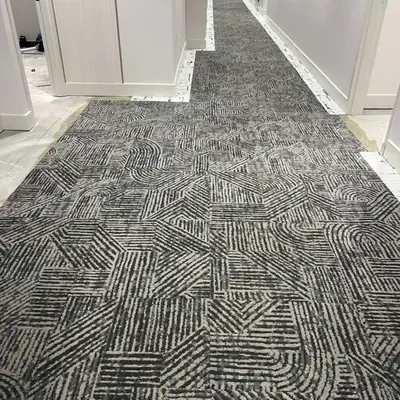 Gray patterned carpet tile installed in an office hallway