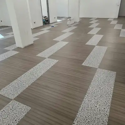 Wood-look vinyl plank with terrazzo-look inlay strips in an office