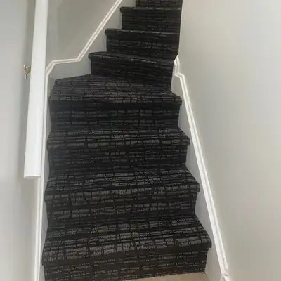 Black and white patterned carpet installed on winder stairs