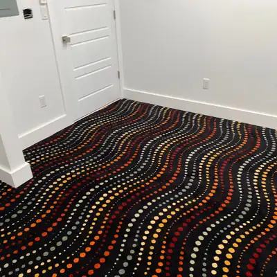 Black carpet with rows of colorful dots installed in a playroom
