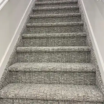 Patterned gray carpet installed on a long staircase