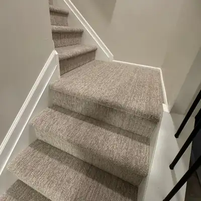 Textured beige carpet installed on winder stairs